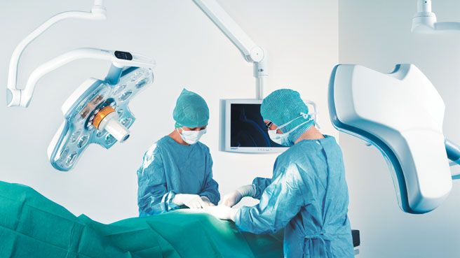 doktori izvode operaciju pod operacionim lampama